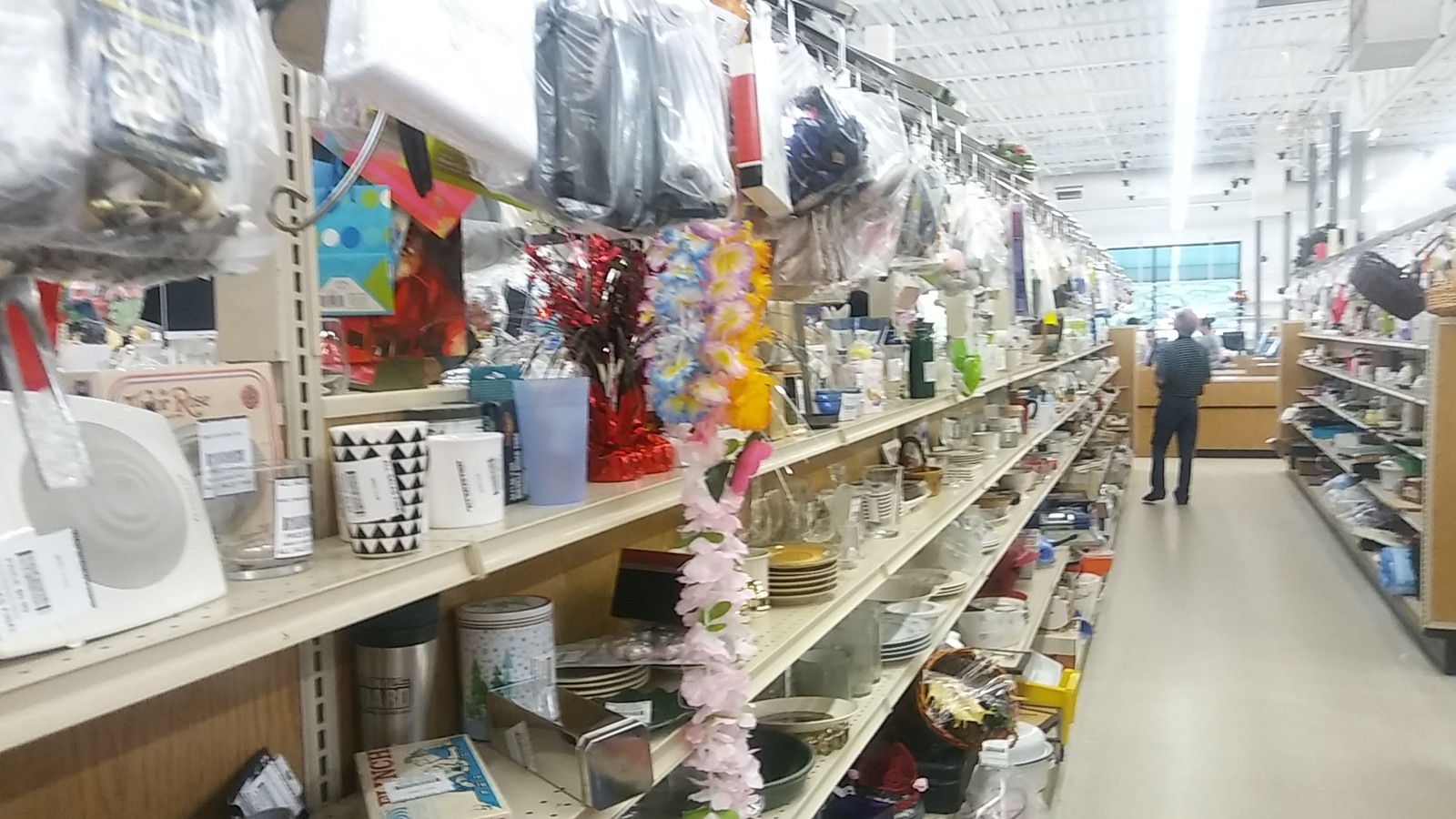 Long housewares aisle filled with dishes and decor at Valley Thrift Store