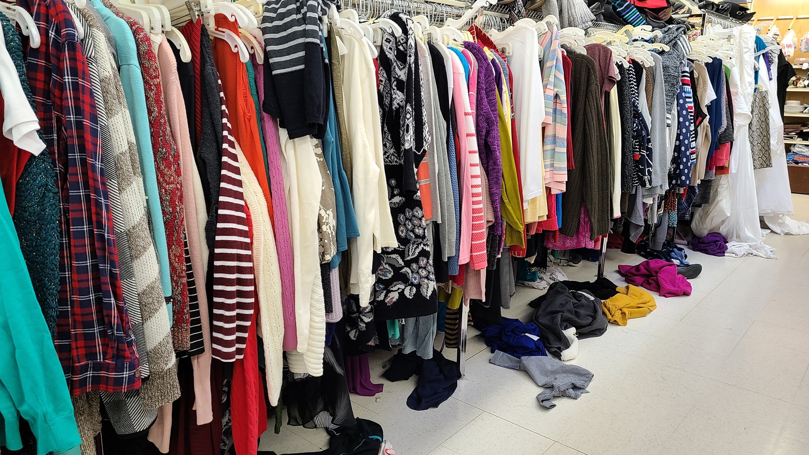 Colorful shirts and dresses on full clothing racks at Valley Thrift Store