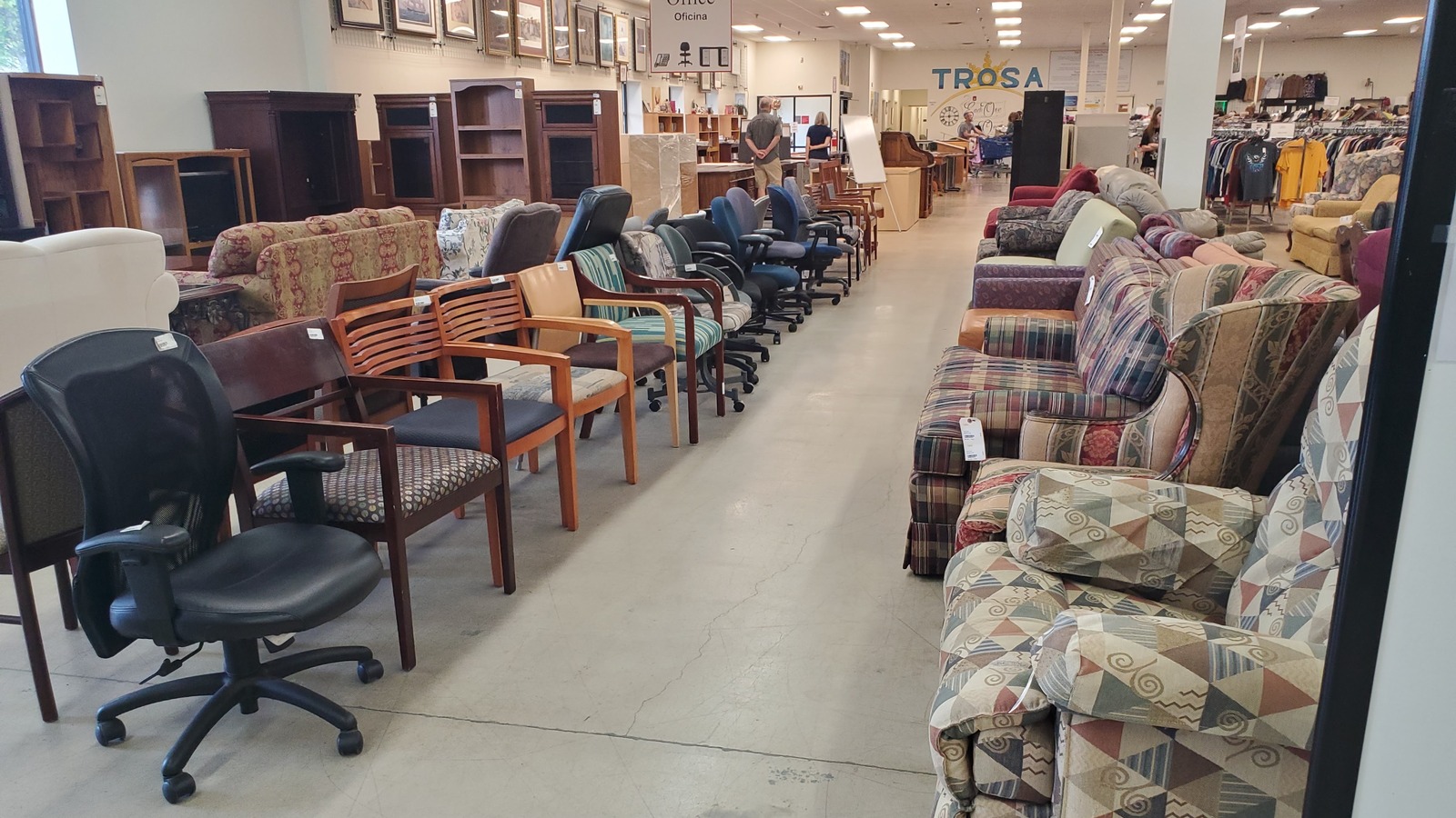 Long rows of sofas, chairs, tables, and framed art inside TROSA Thrift Store in Winston-Salem