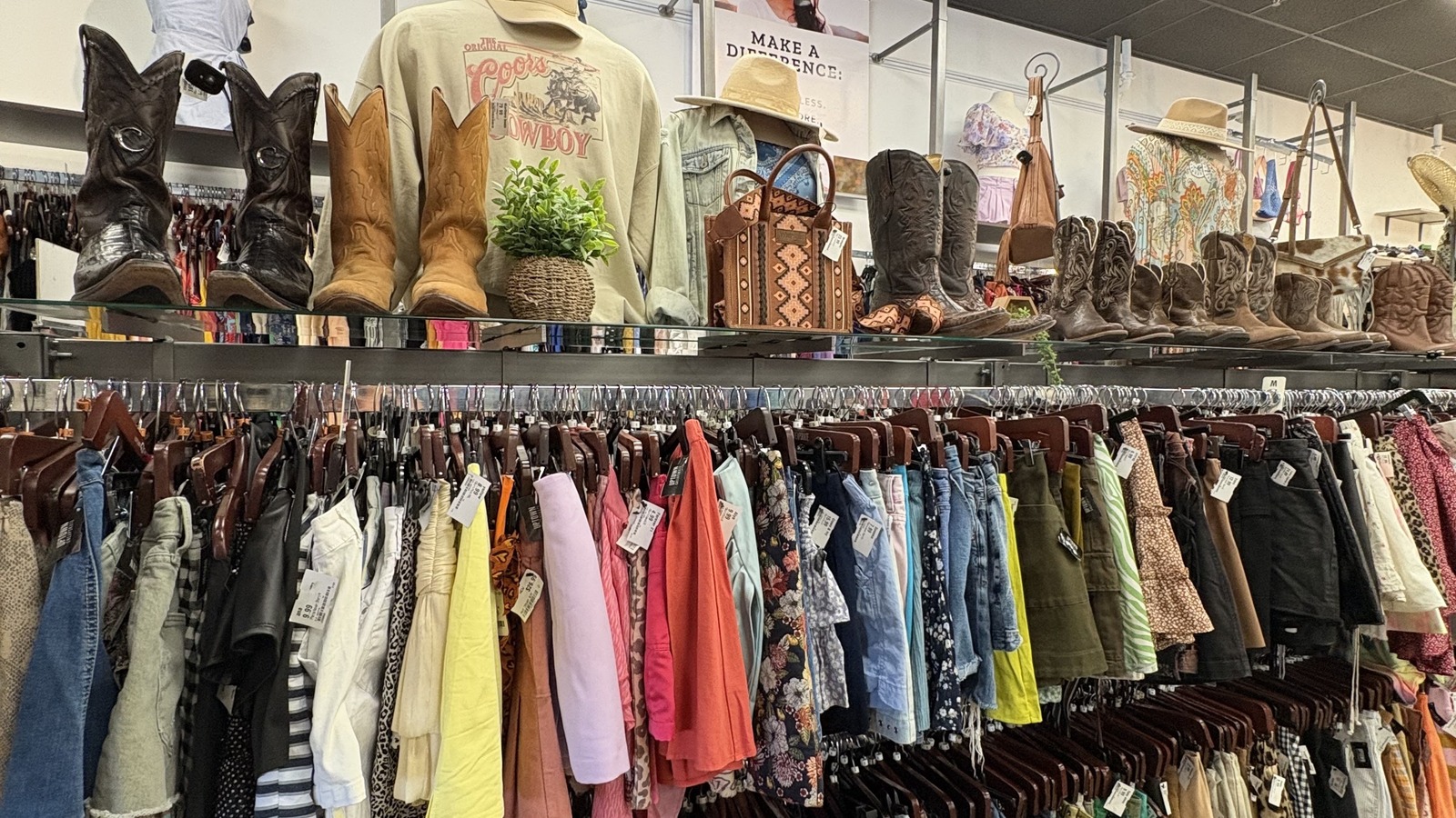 Boots, sweaters, dresses, and colorful clothing racks inside Uptown Cheapskate Winston Salem
