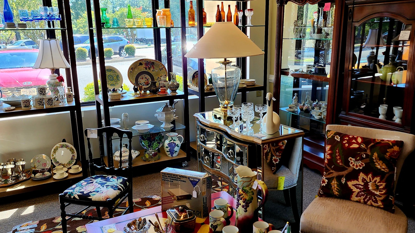 Cabinets filled with glassware, lamps, and home accents at new2you Thrift Store