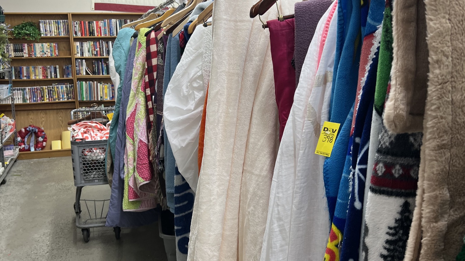 Long clothing racks organized by size inside DAV Thrift Store in Williamsburg