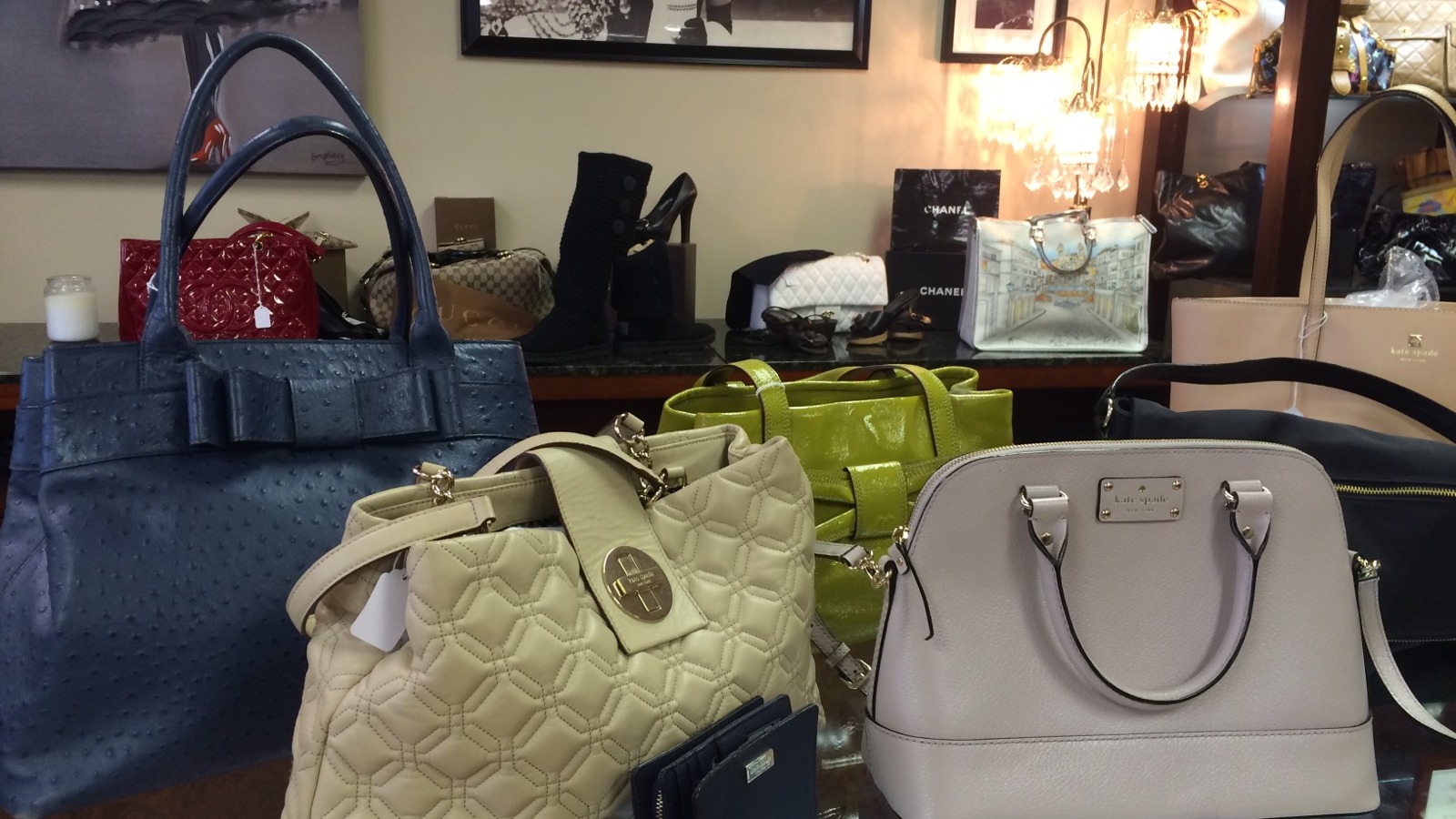 Designer handbags displayed on shelves at Ladybug Consignment and Boutique