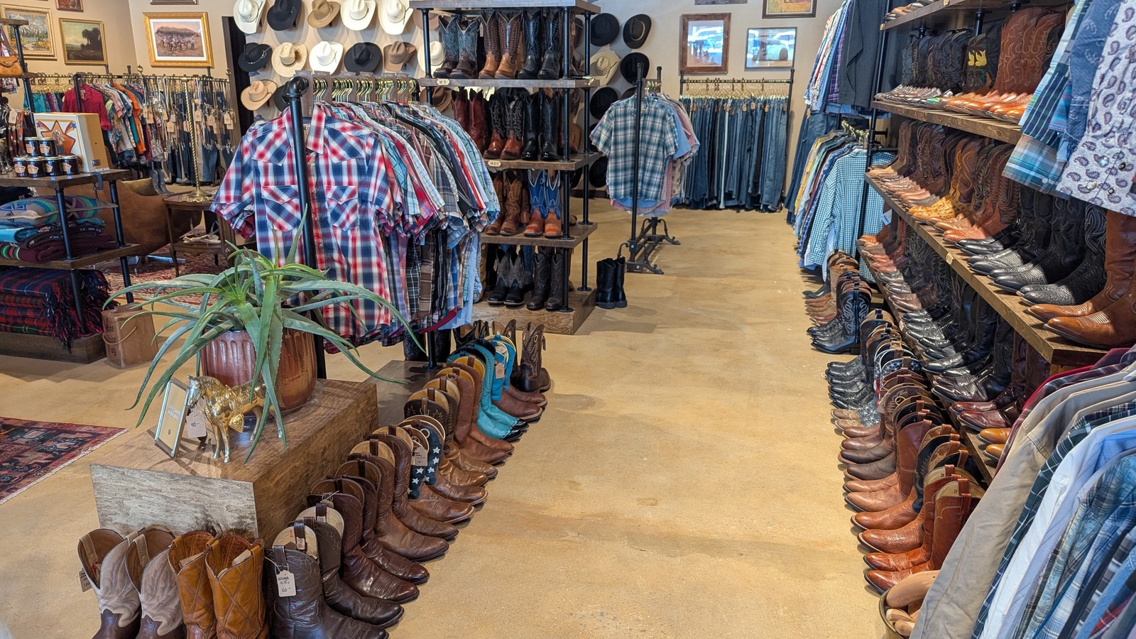 Rows of cowboy boots and Western hats inside South Western Second Hand
