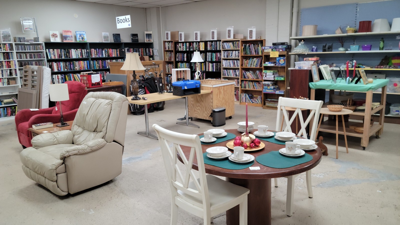 Furniture, books, and housewares arranged inside ACTS Resale Store in Aiken