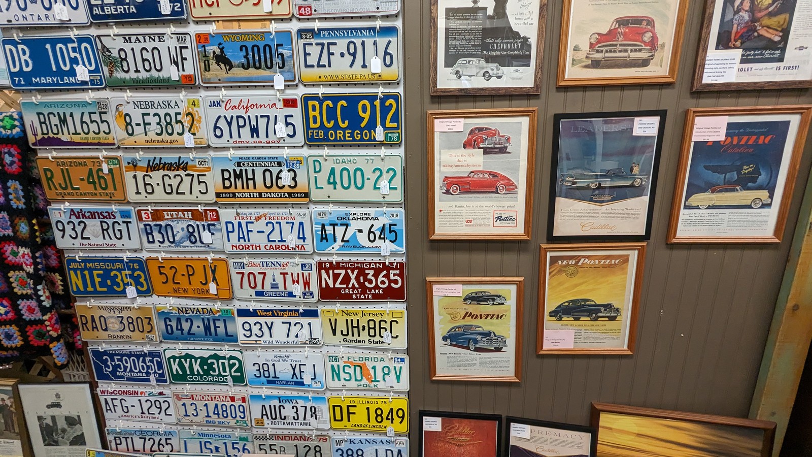 Vintage license plates and framed automotive art at Antiques & More in Aiken