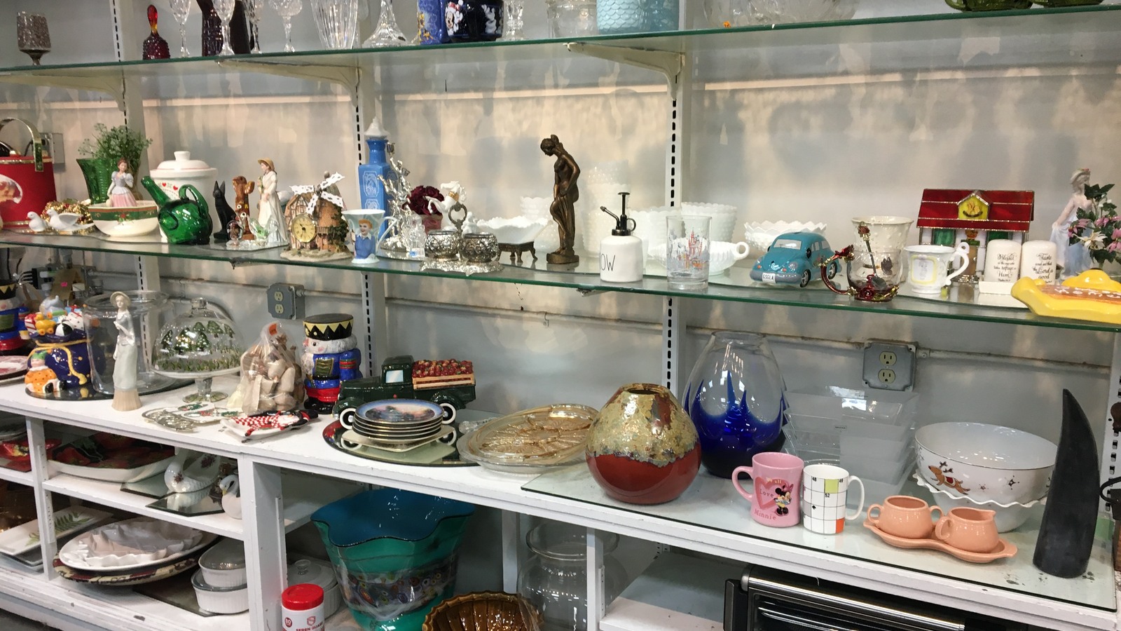 Figurines, pottery, and decorative collectibles in a glass cabinet
