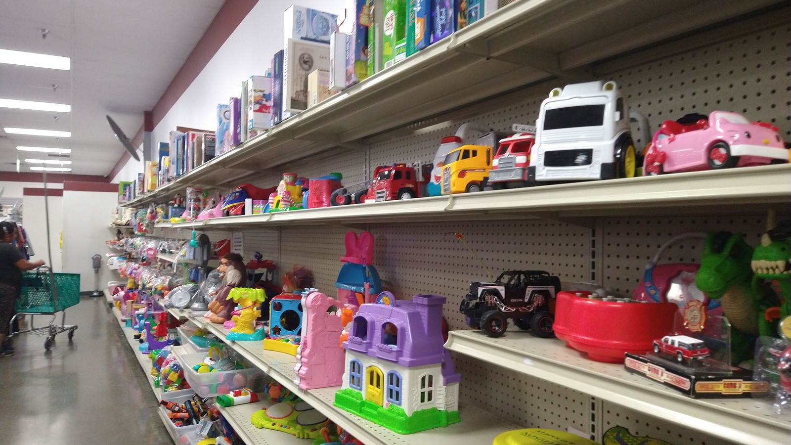 Toy cars, dolls, and playsets arranged on long shelves