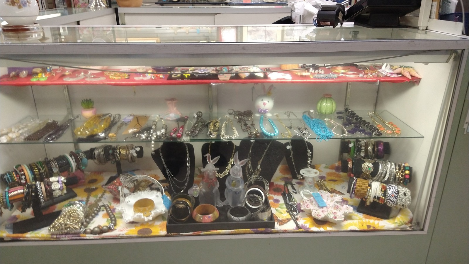 Bracelets, necklaces, watches, and small treasures in a glass case