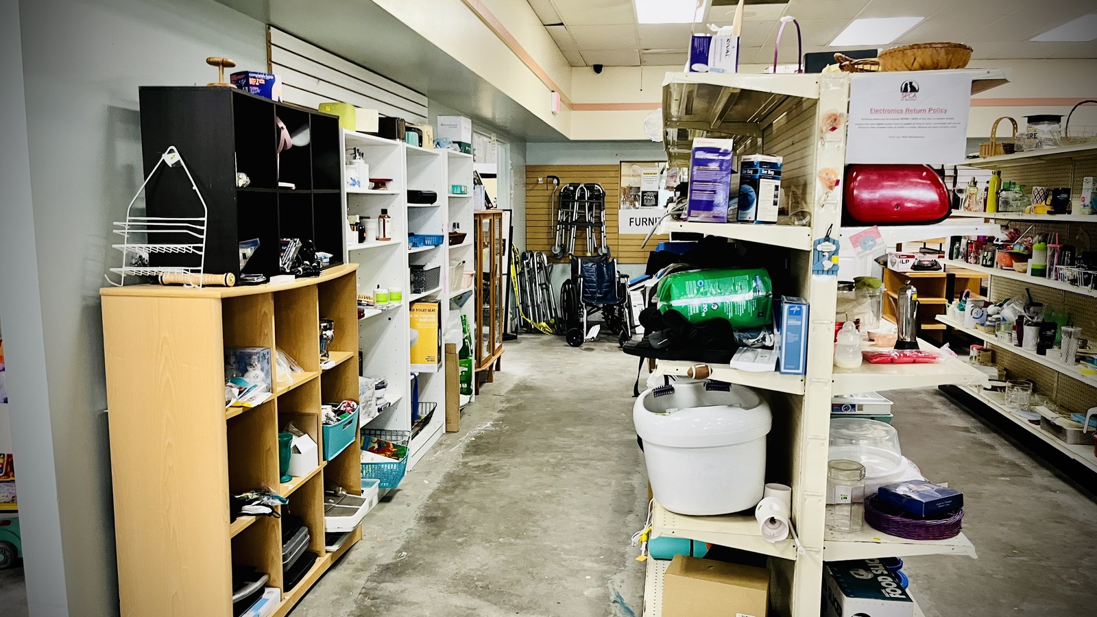 Merchandise shelves and open aisle inside SPCA Thrift Store in Titusville