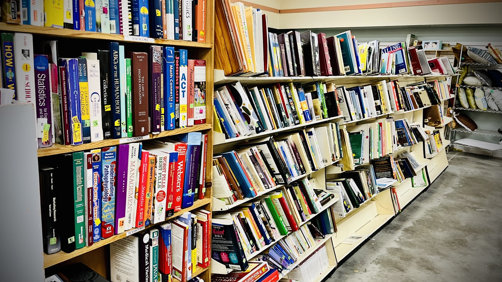 Long bookshelves filled with colorful secondhand titles