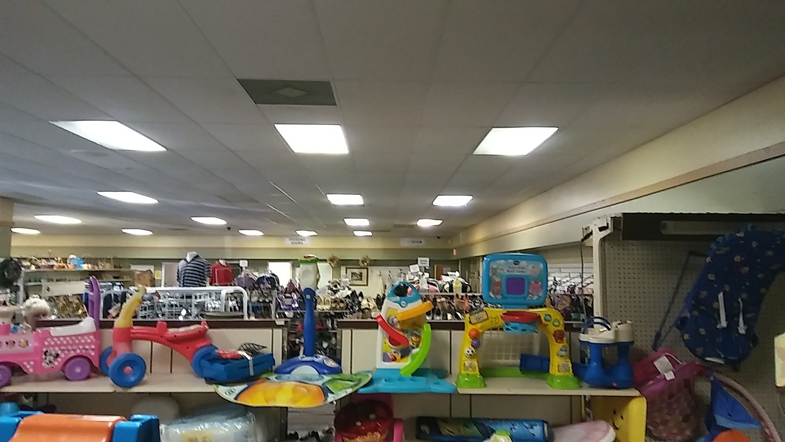Children's ride-on toys and playthings across a bright department