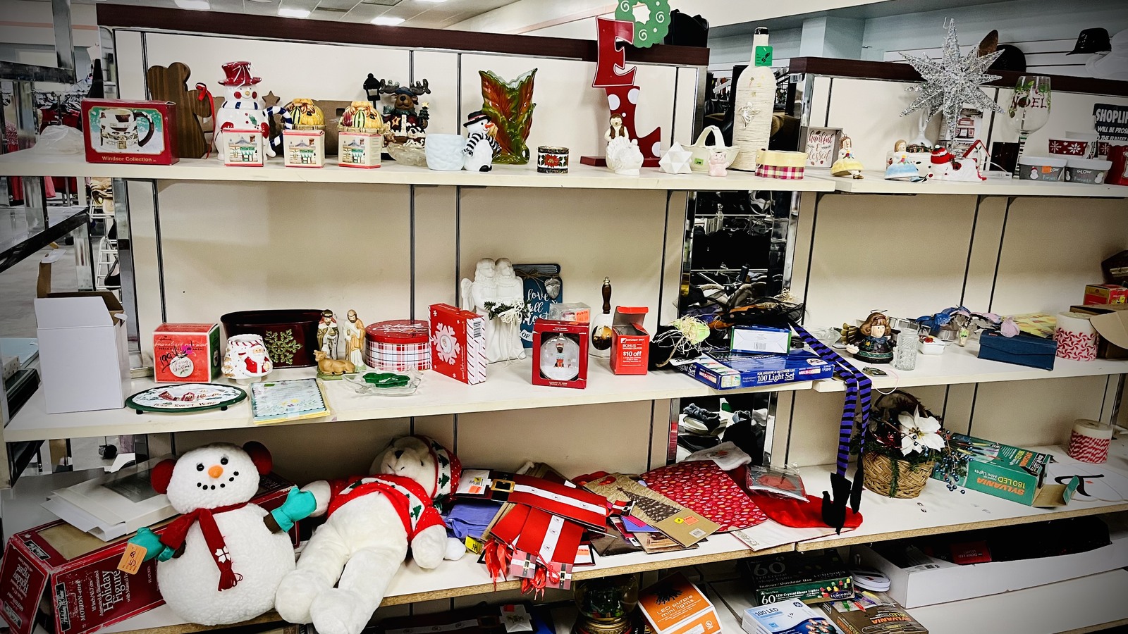 Seasonal decor, ornaments, and plush pieces on white shelves