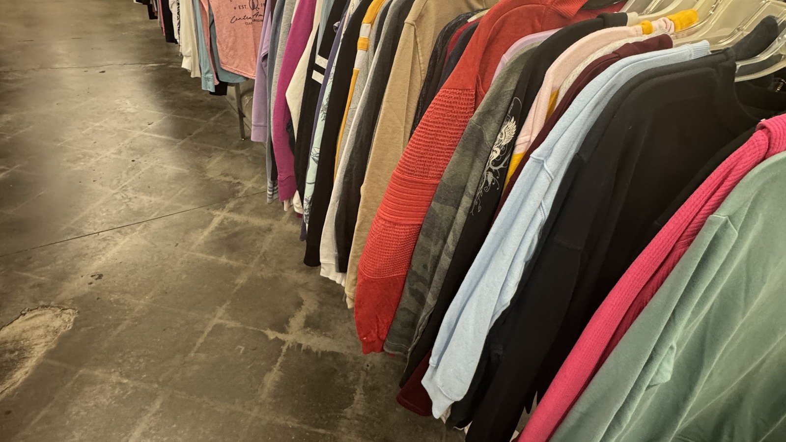 Colorful shirts and jackets arranged on clothing racks