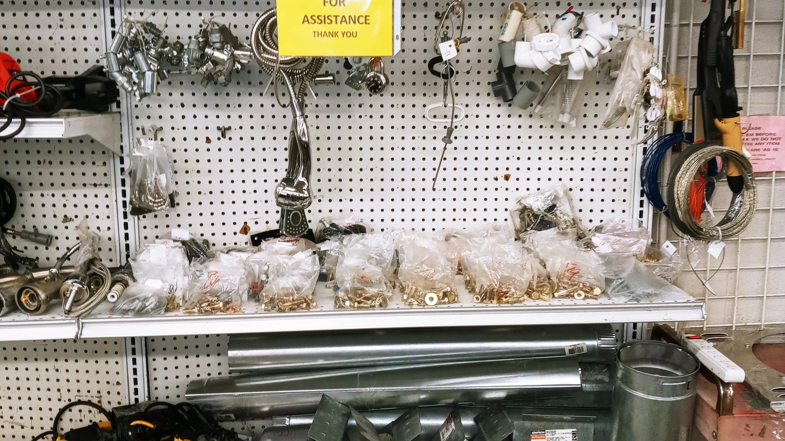 Silver seasonal ornaments and decorative accents on pegboard shelves