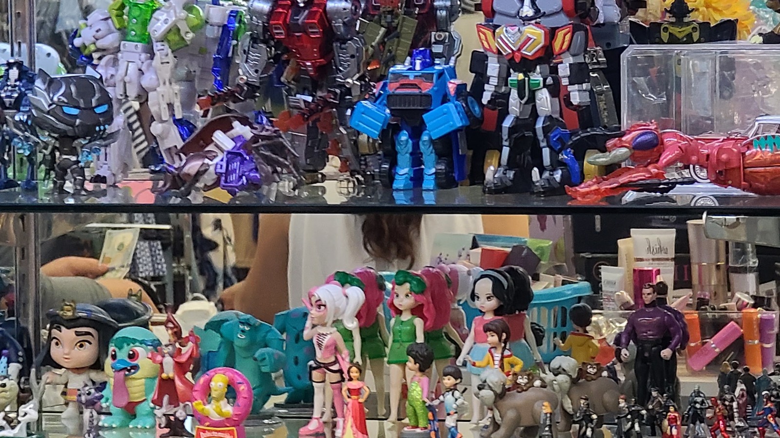 Robots, action figures, dolls, and small toys in glass displays