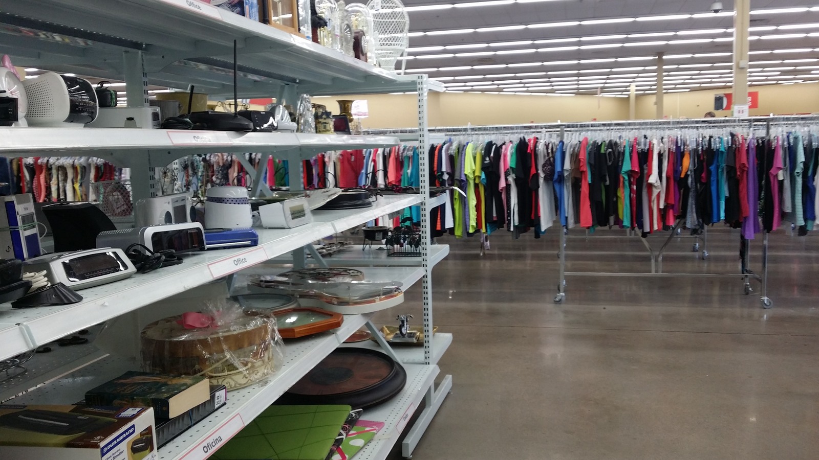 Housewares shelves beside neatly arranged clothing racks