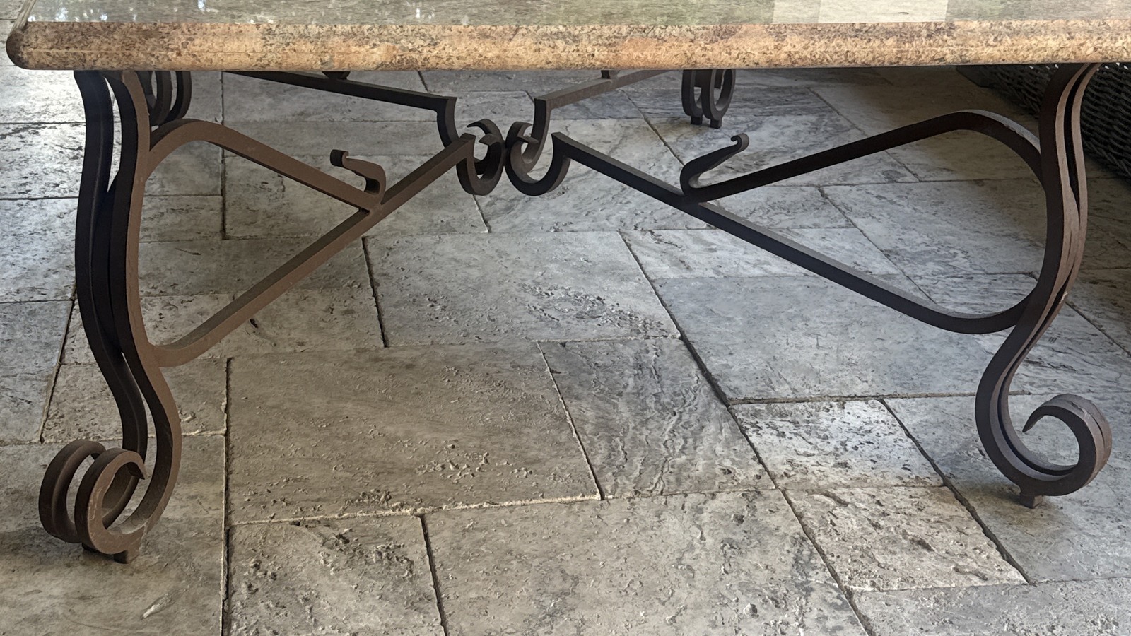 Decorative metal and glass table with a scrollwork base