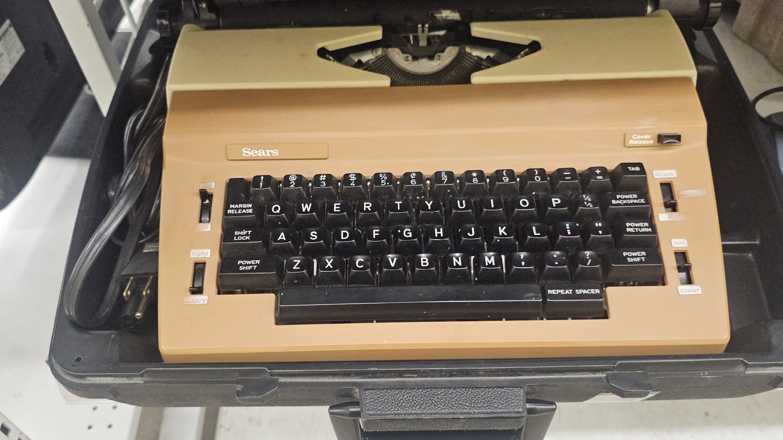 Tan Sears typewriter displayed in an open carrying case