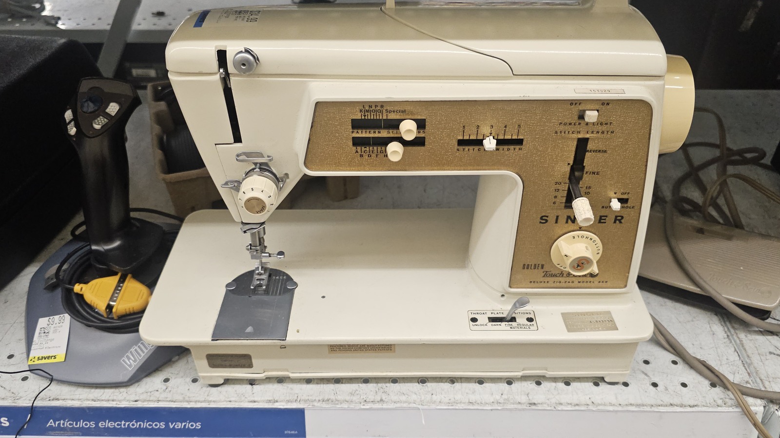 Cream Singer sewing machine on an electronics shelf