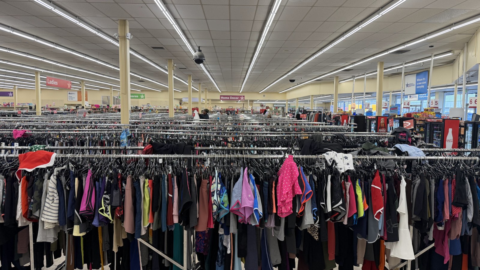 Long rows of colorful clothing racks across the Alabaster sales floor
