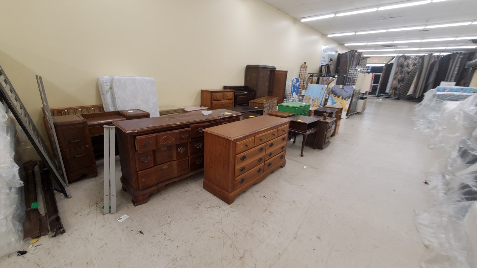 Wood dressers, tables, desks, and bed frames in the furniture area