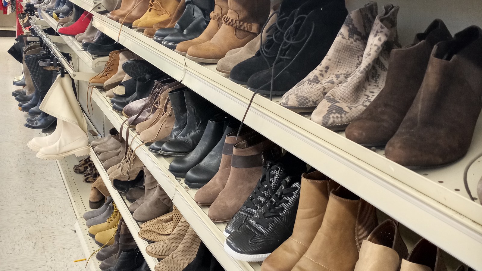 Boots, flats, and casual shoes arranged across long shelves