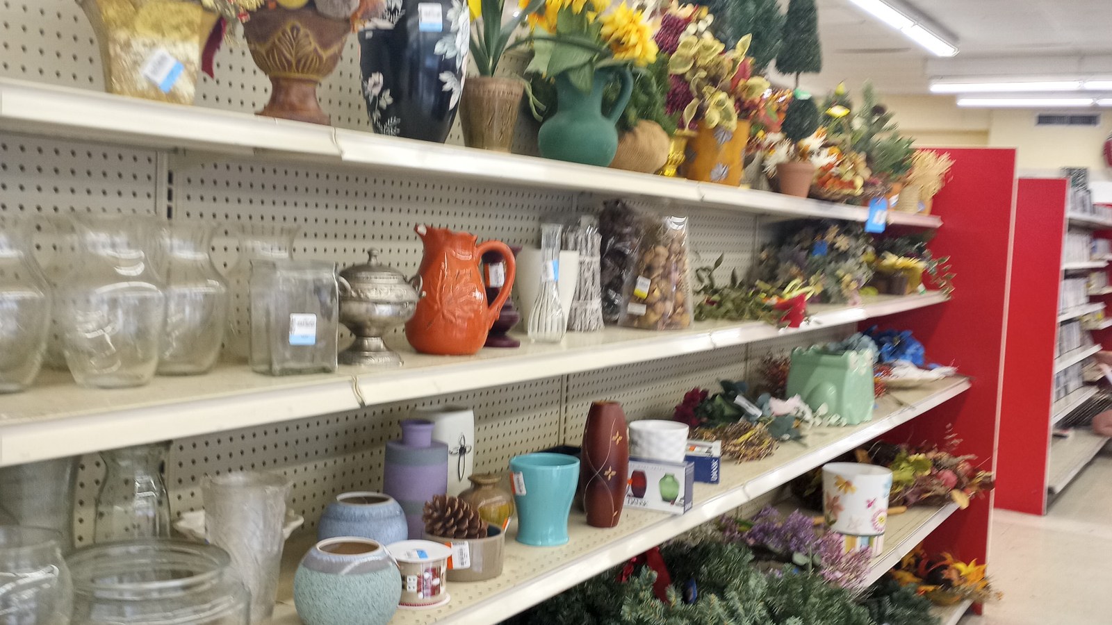 Glassware, vases, pottery, and faux flowers on housewares shelves