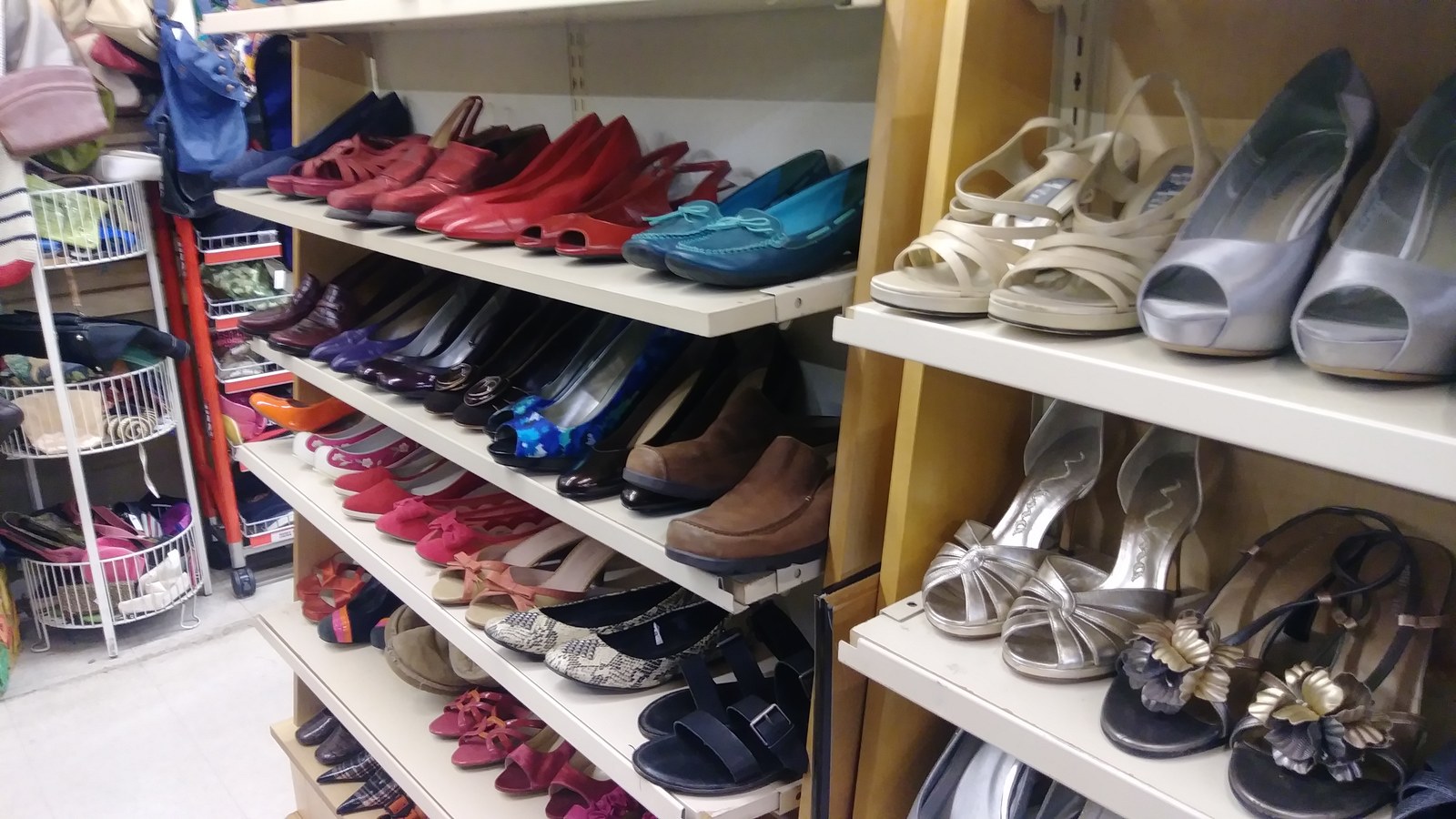 Colorful heels, flats, and sandals arranged on shoe shelves
