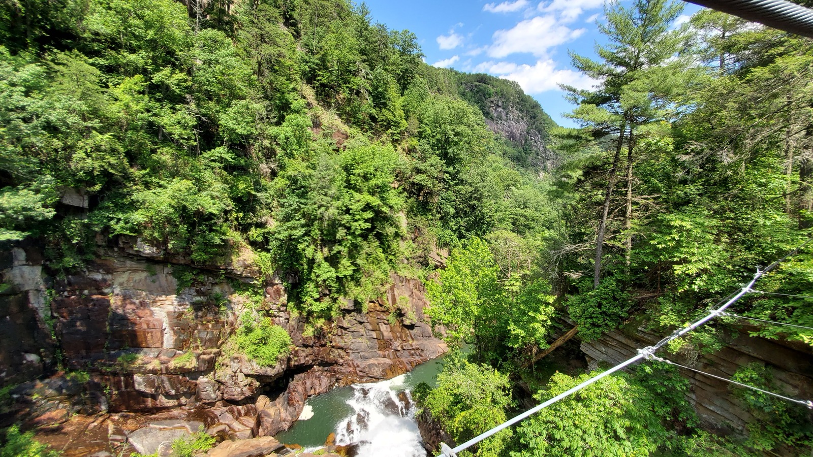 Suspension bridge crossing above the gorge with rock walls and river below at Tallulah Gorge State Park.