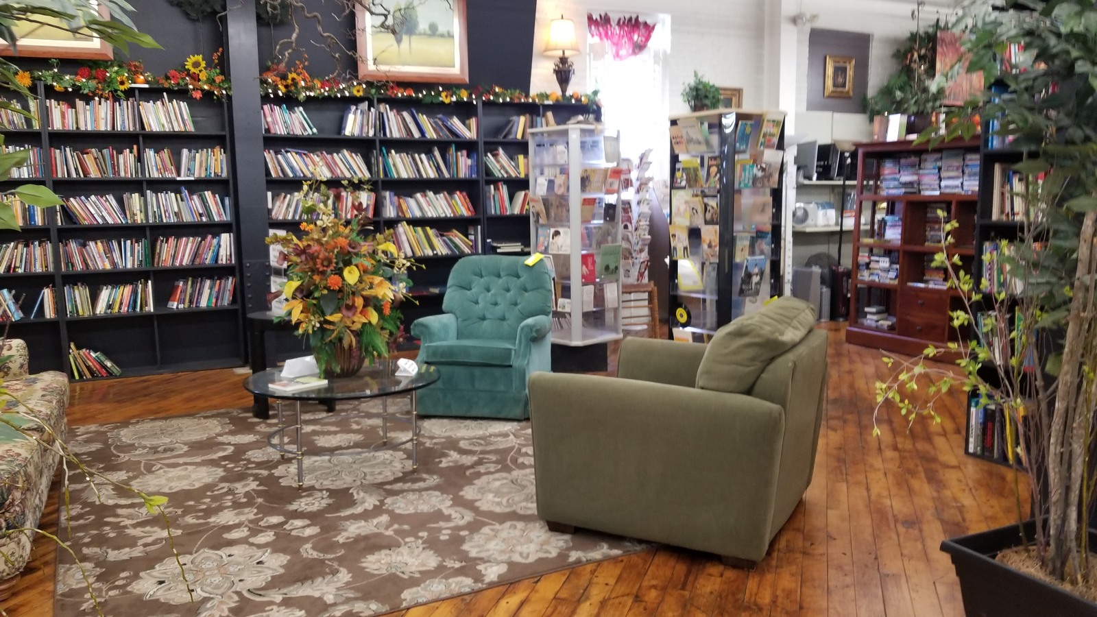 Books, armchairs, flowers, and a rug arranged in a cozy seating area