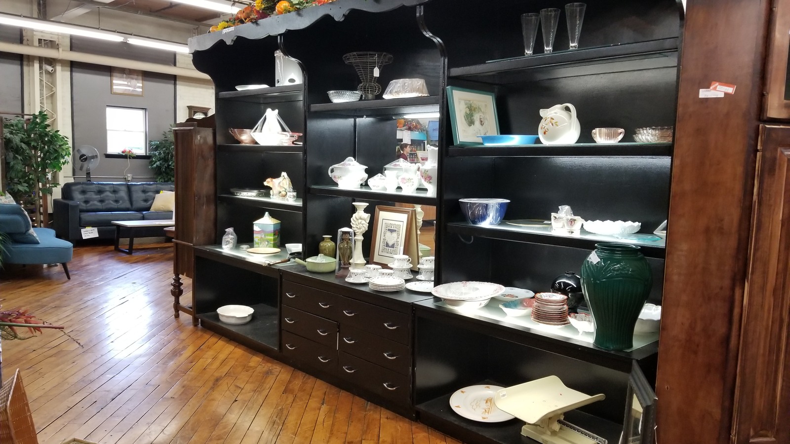 White dishes, glassware, and collectibles displayed in a dark wood cabinet