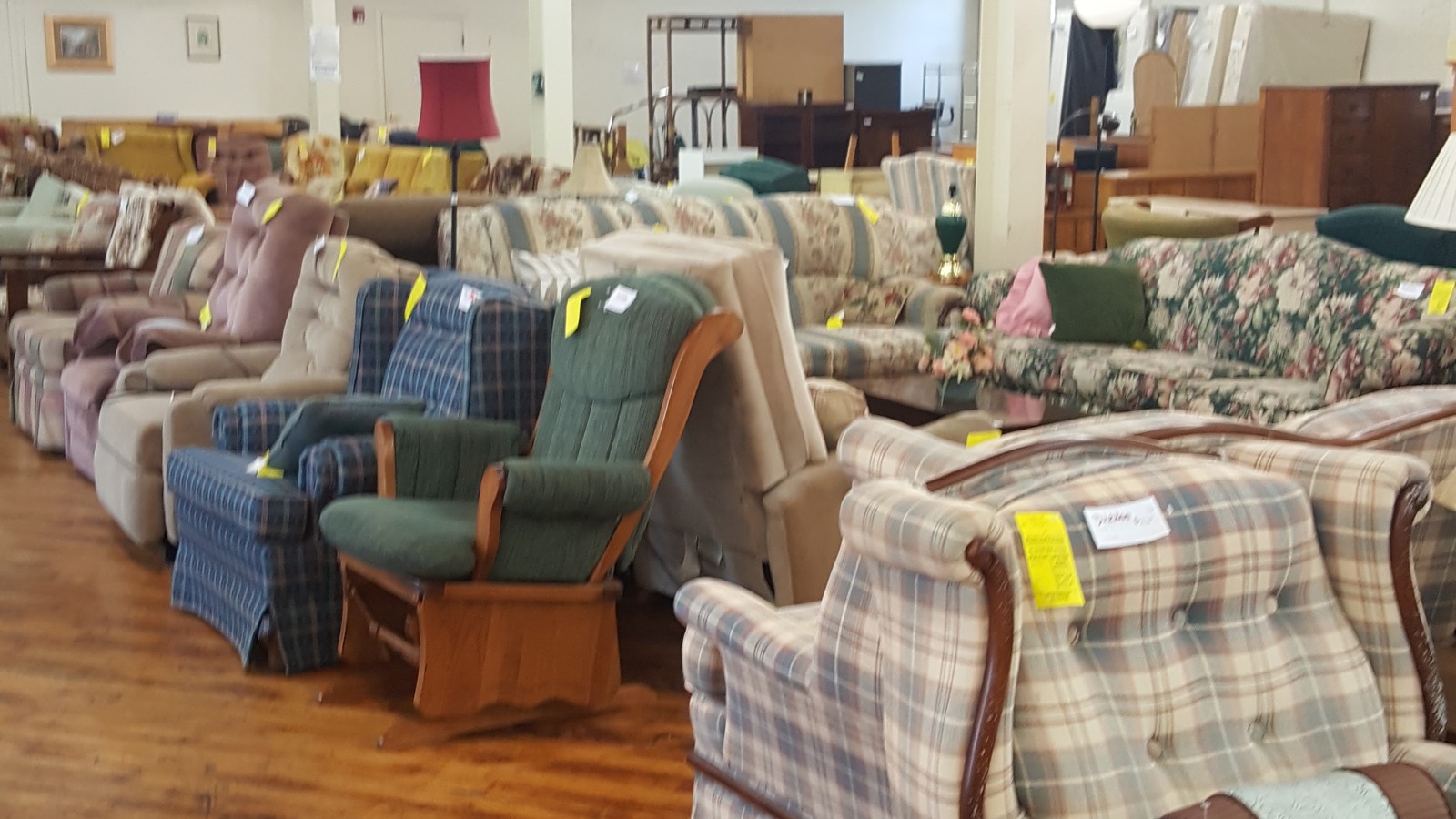 Rows of patterned recliners and armchairs on a polished wood floor