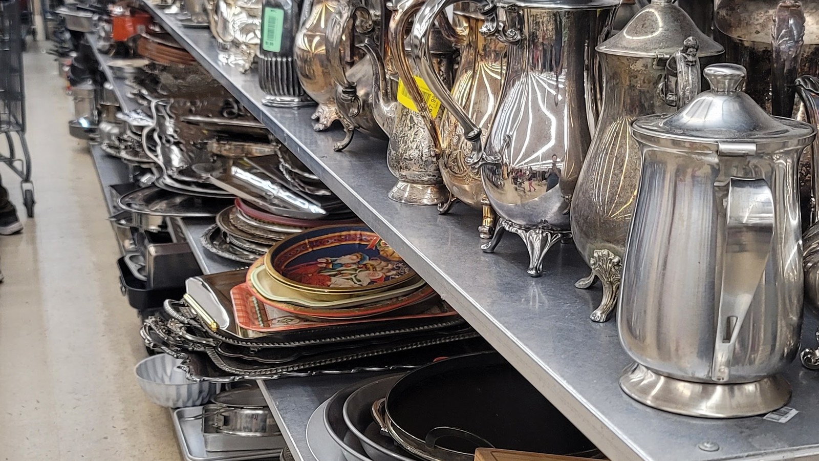 Silver-toned serving pieces and platters on open shelves