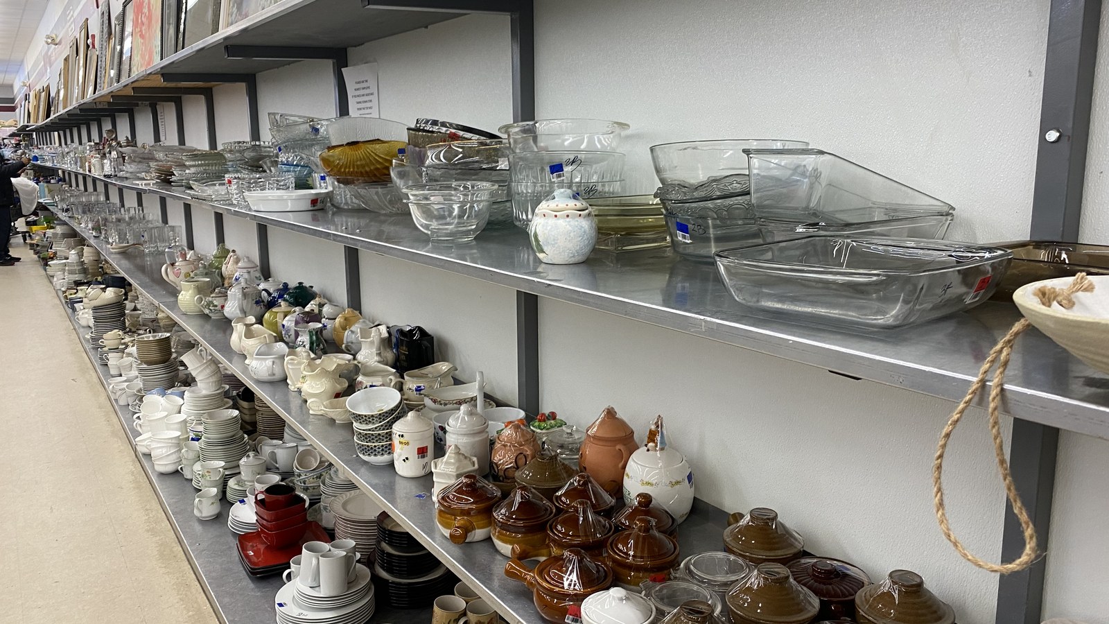 Clear glass dishes, jars, and serving pieces arranged on metal shelves