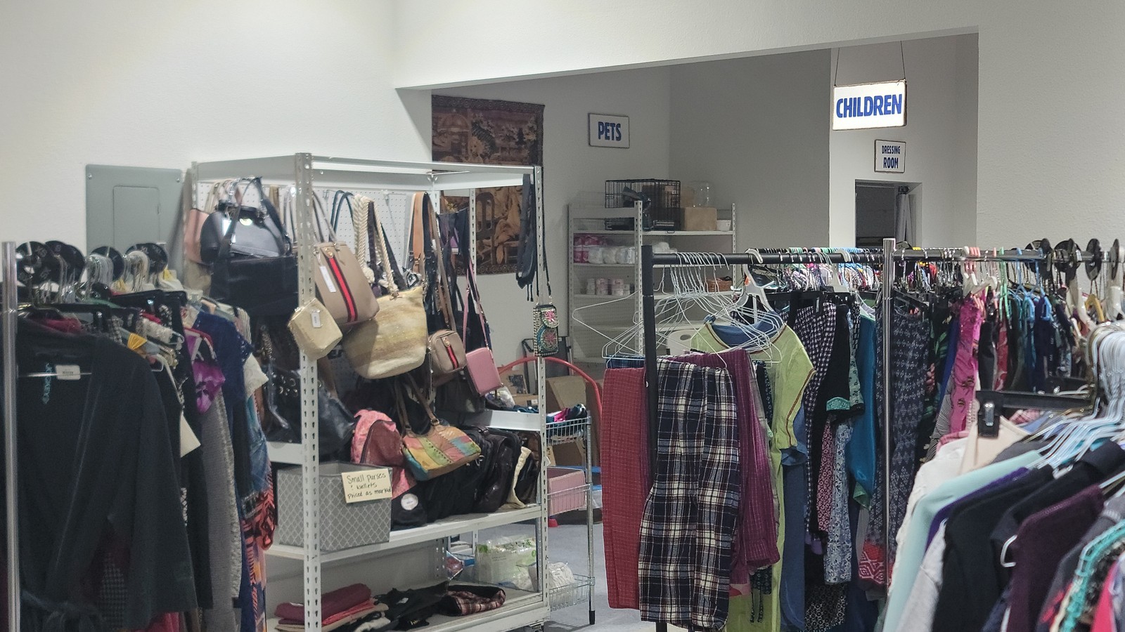 Neatly arranged clothing racks inside Giving4Pets Thrift Store in Sun City