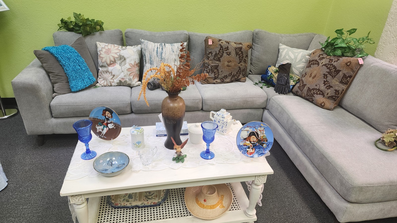 Sofa, pillows, and home decor arranged at Glorious Treasures Thrift Store