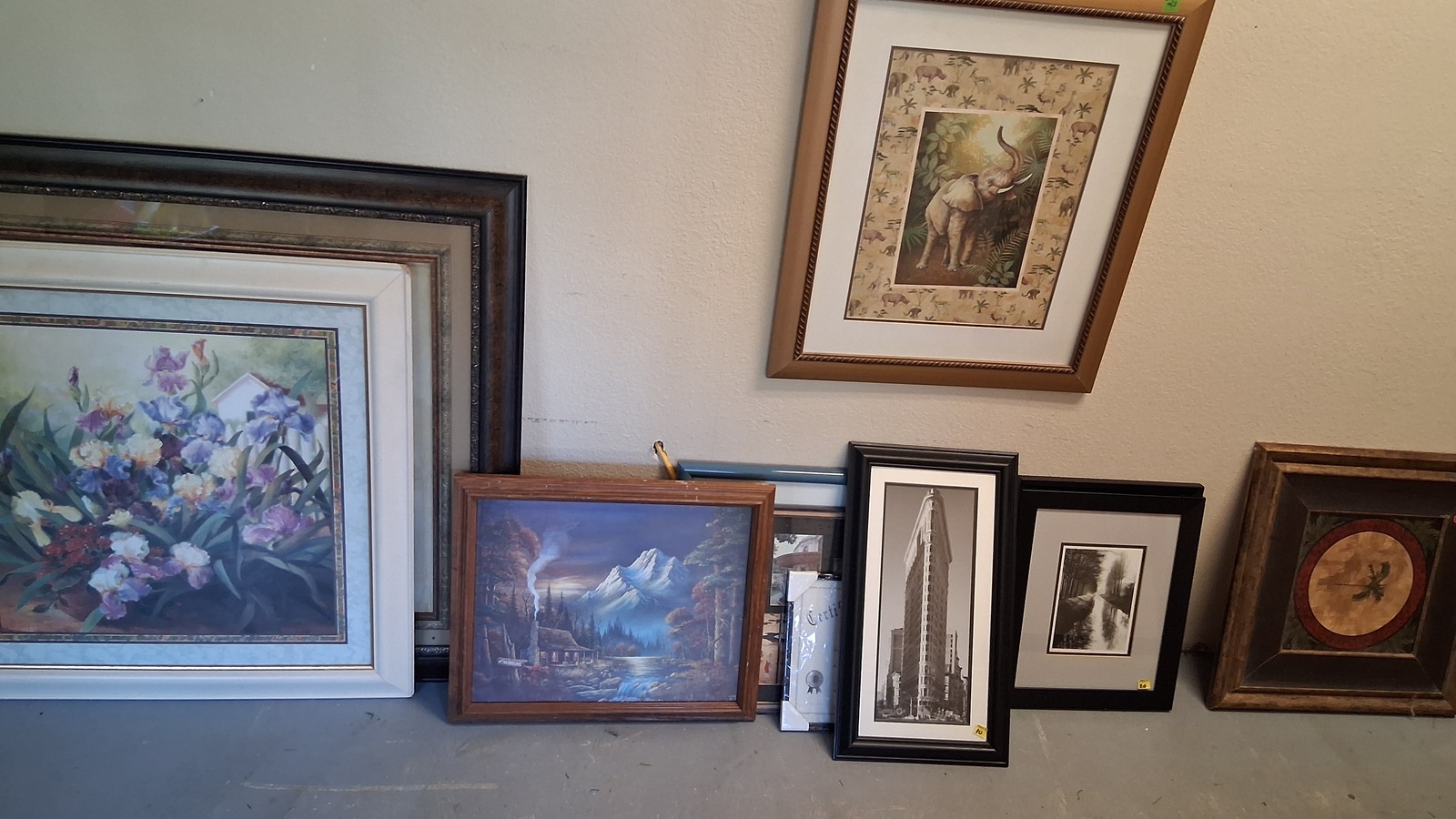 Framed landscapes, floral art, and decorative prints at Homeless Shelter Thrift Store in Murphy