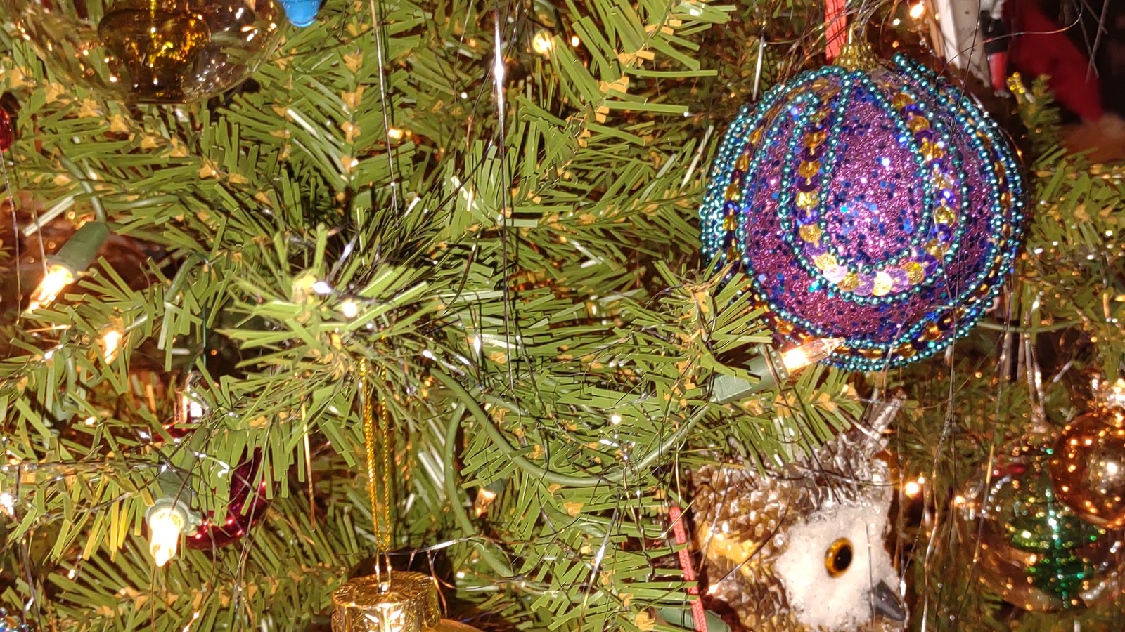 Colorful ornament and owl decoration on a Christmas tree at Logan's Run Rescue and Thrift Store in Murphy