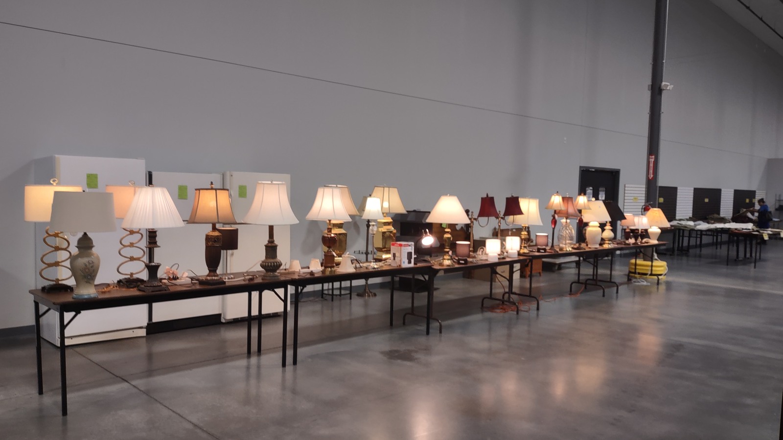 Long row of table lamps glowing inside the Burlington thrift store