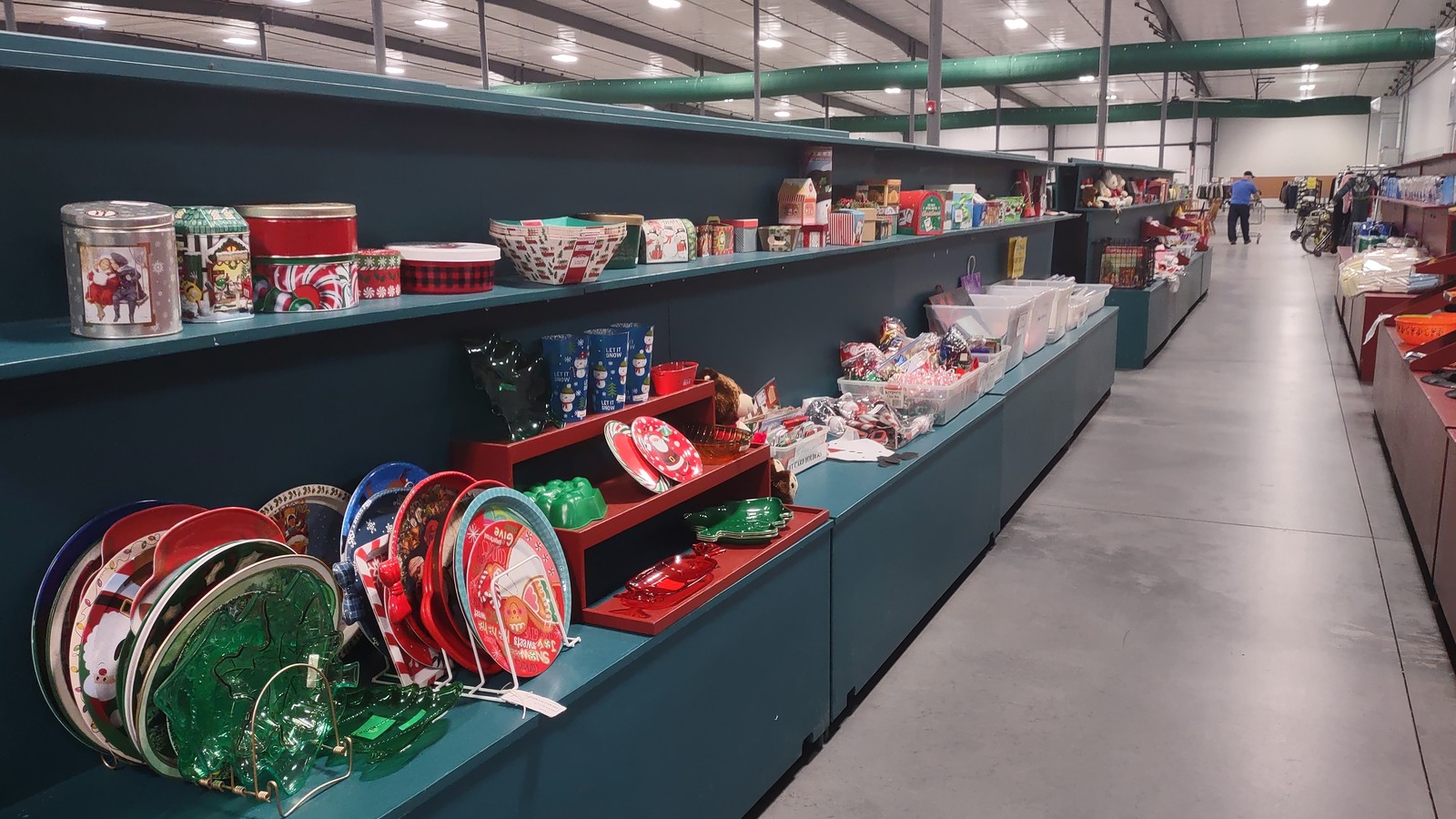 Colorful serving trays and housewares displayed on long green shelves