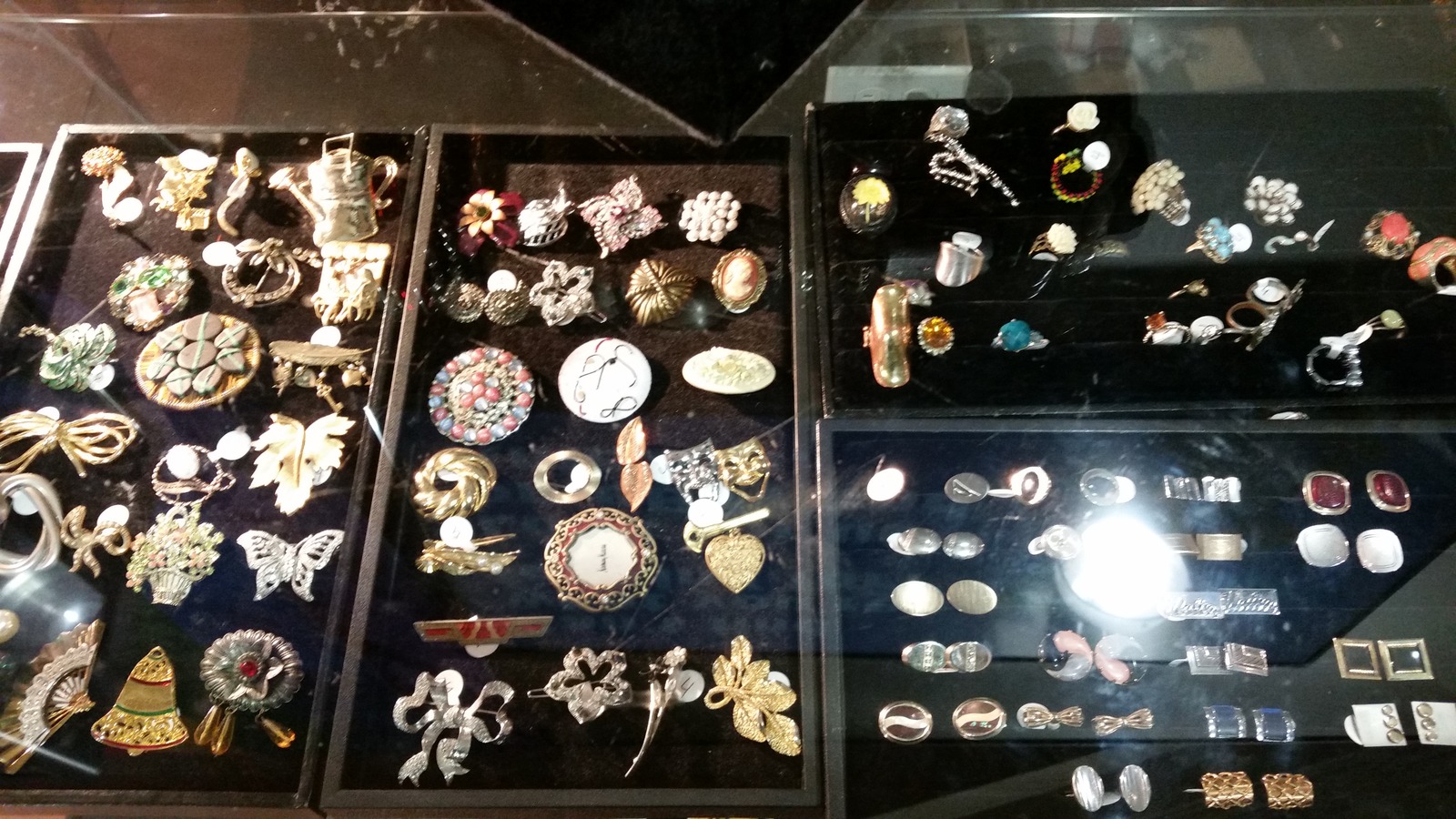 Jewelry and small collectibles displayed in cases at Brown Elephant