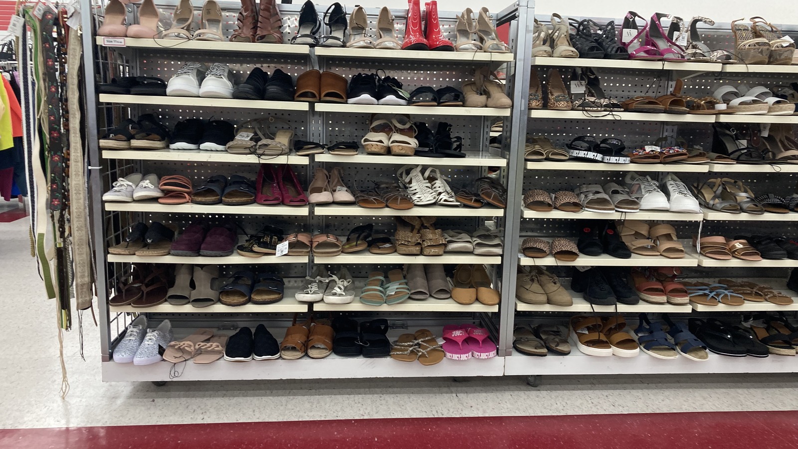 Rows of secondhand shoes organized on metal shelves