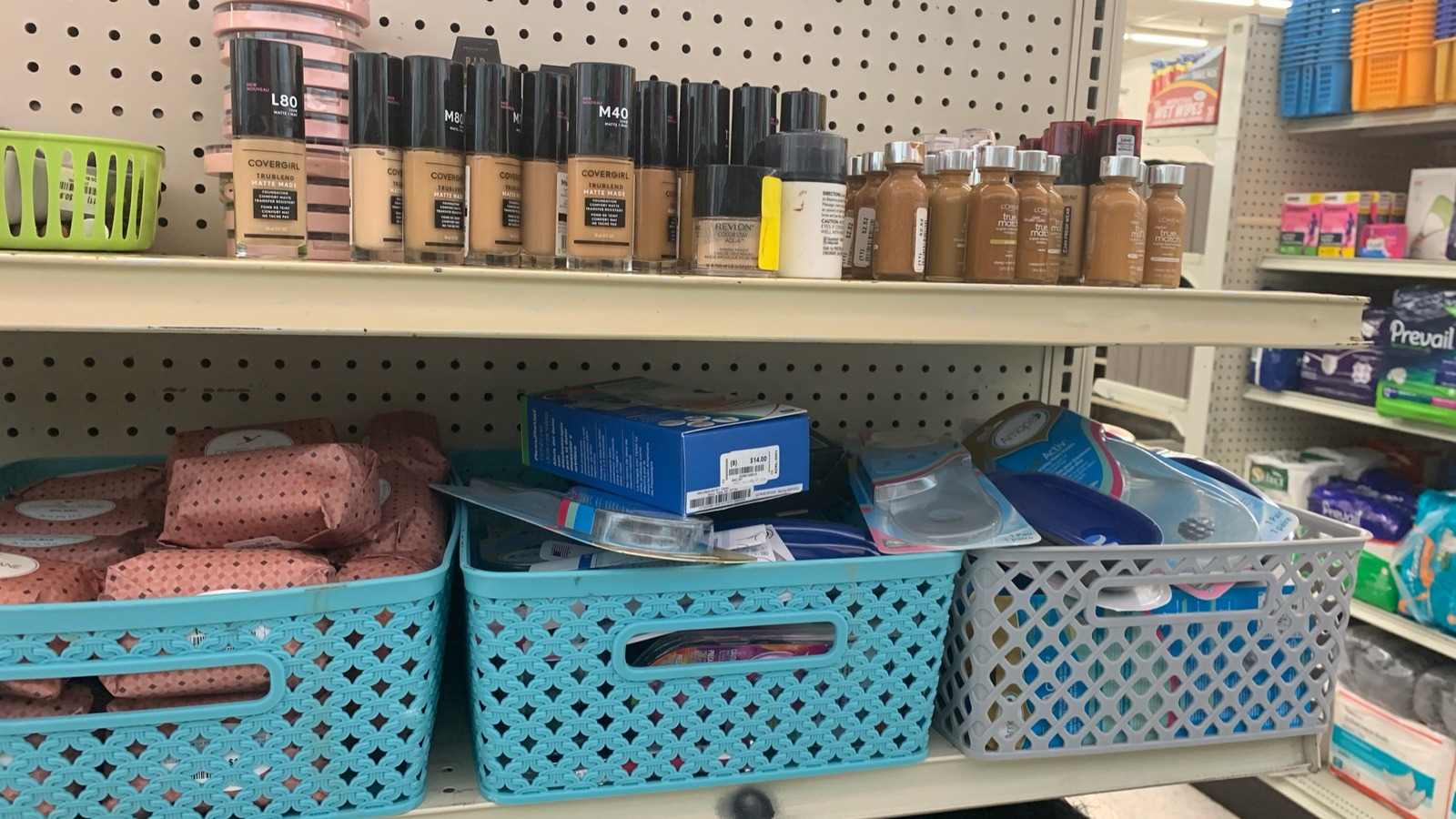 Packaged health and beauty products displayed above storage baskets