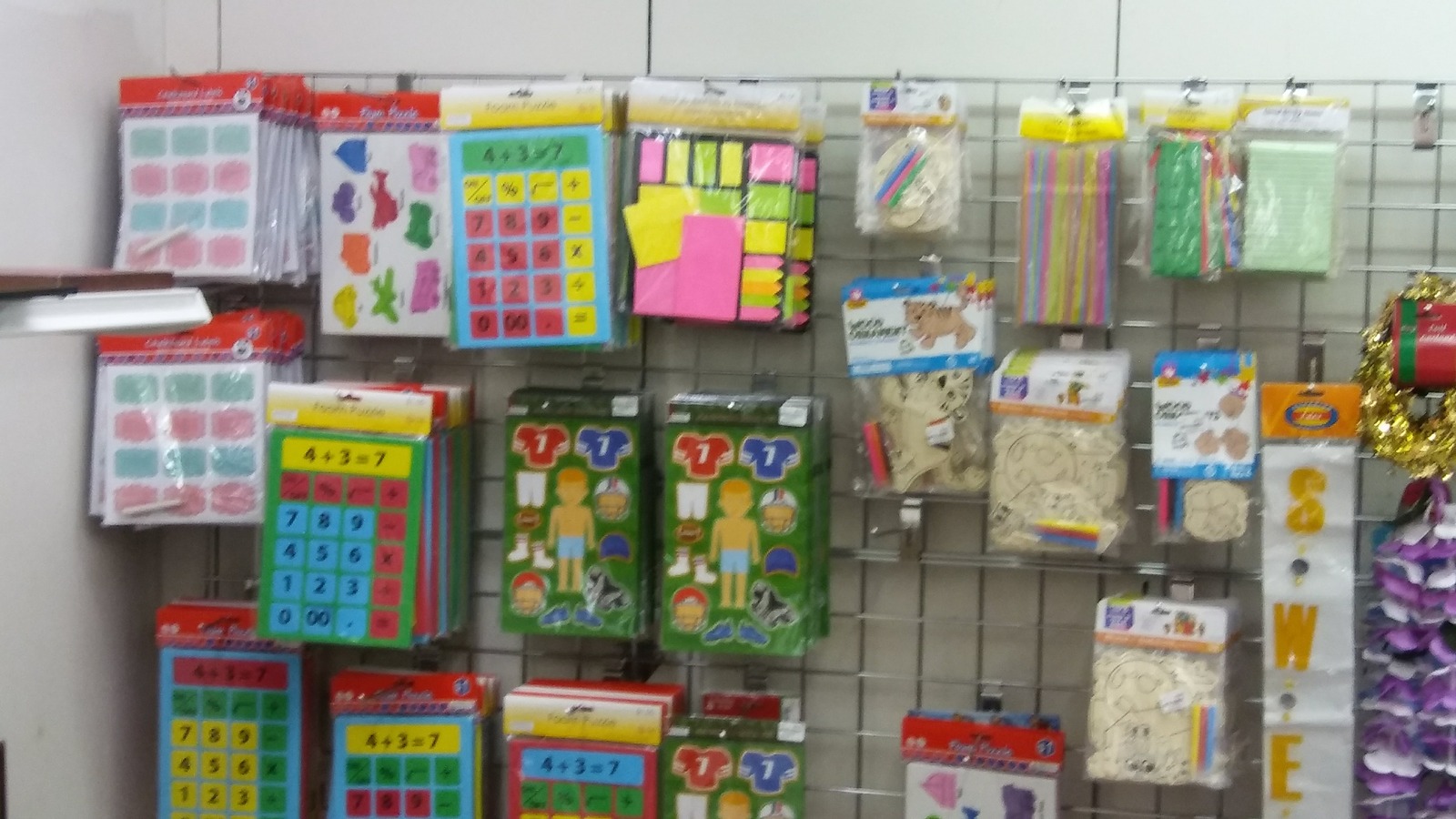 Colorful craft and classroom supplies displayed on pegboard