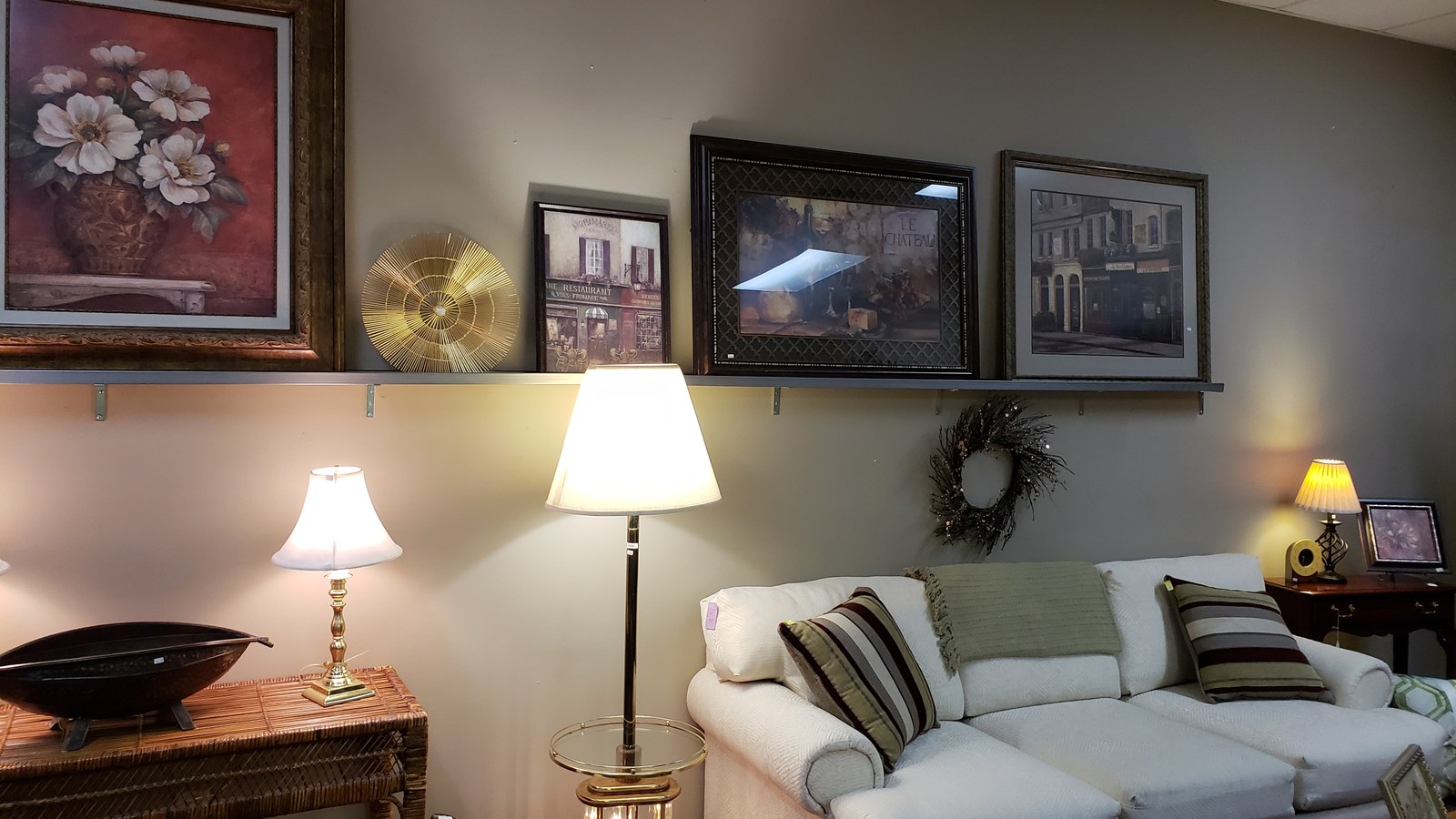 Framed wall art, table lamps, and a sofa arranged as a room display