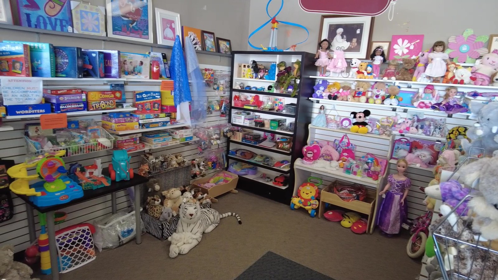 Bright children's toy area with dolls, games, and stuffed animals