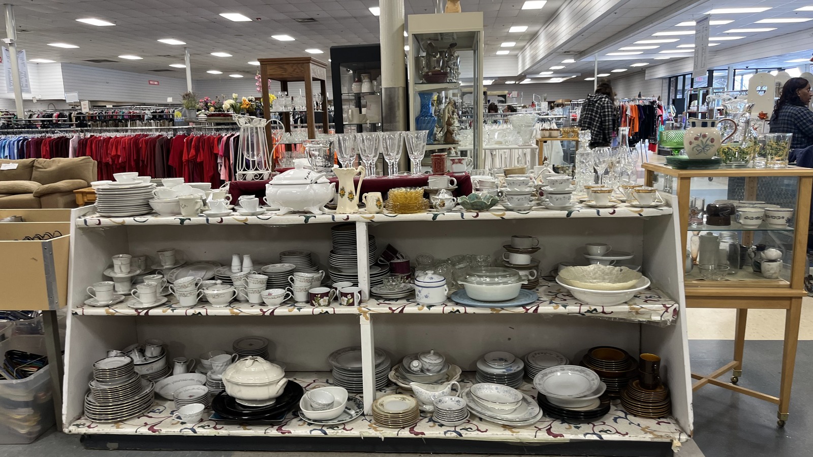 Shelves of dishes and housewares inside Guardian Angel Thrift Store