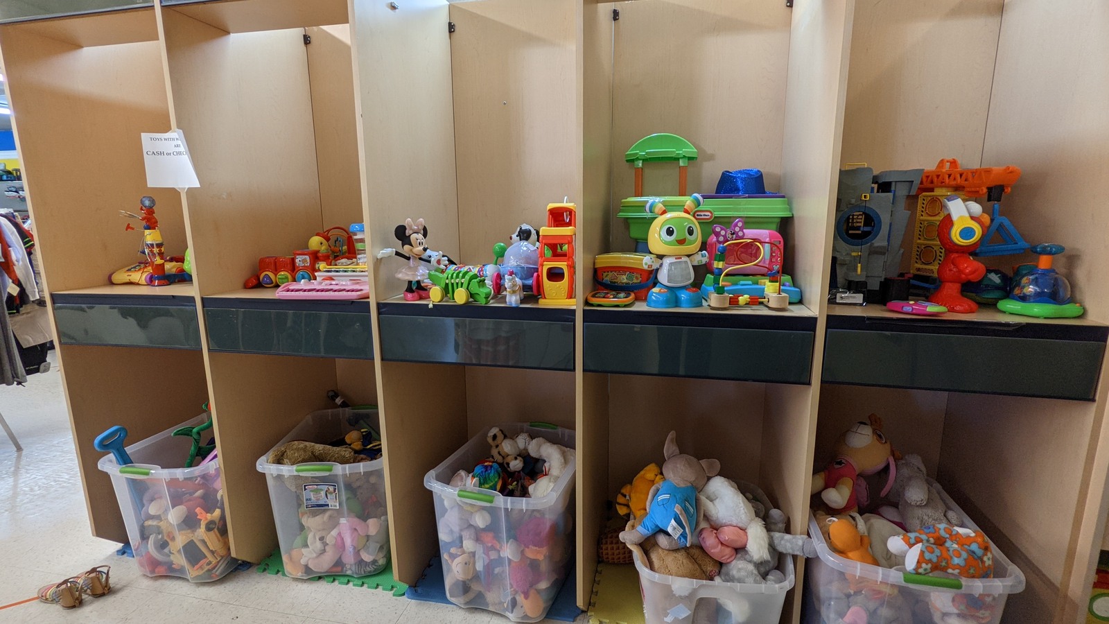 Colorful toys arranged in wooden cubbies at Guardian Angel Thrift Store