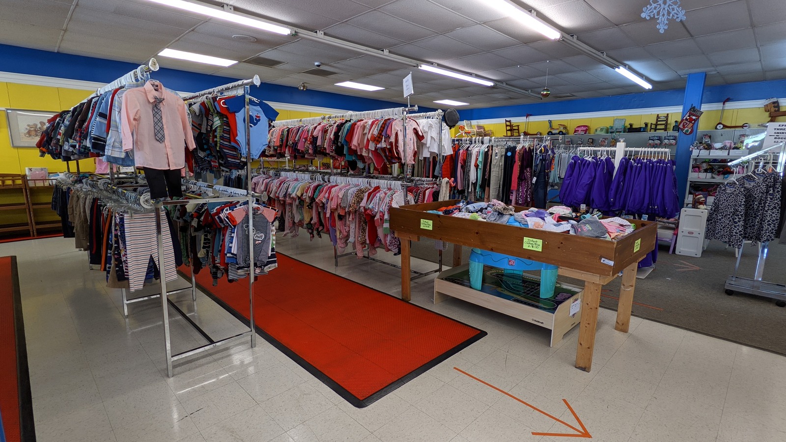 Long organized rows of clothing racks at Guardian Angel Thrift Store